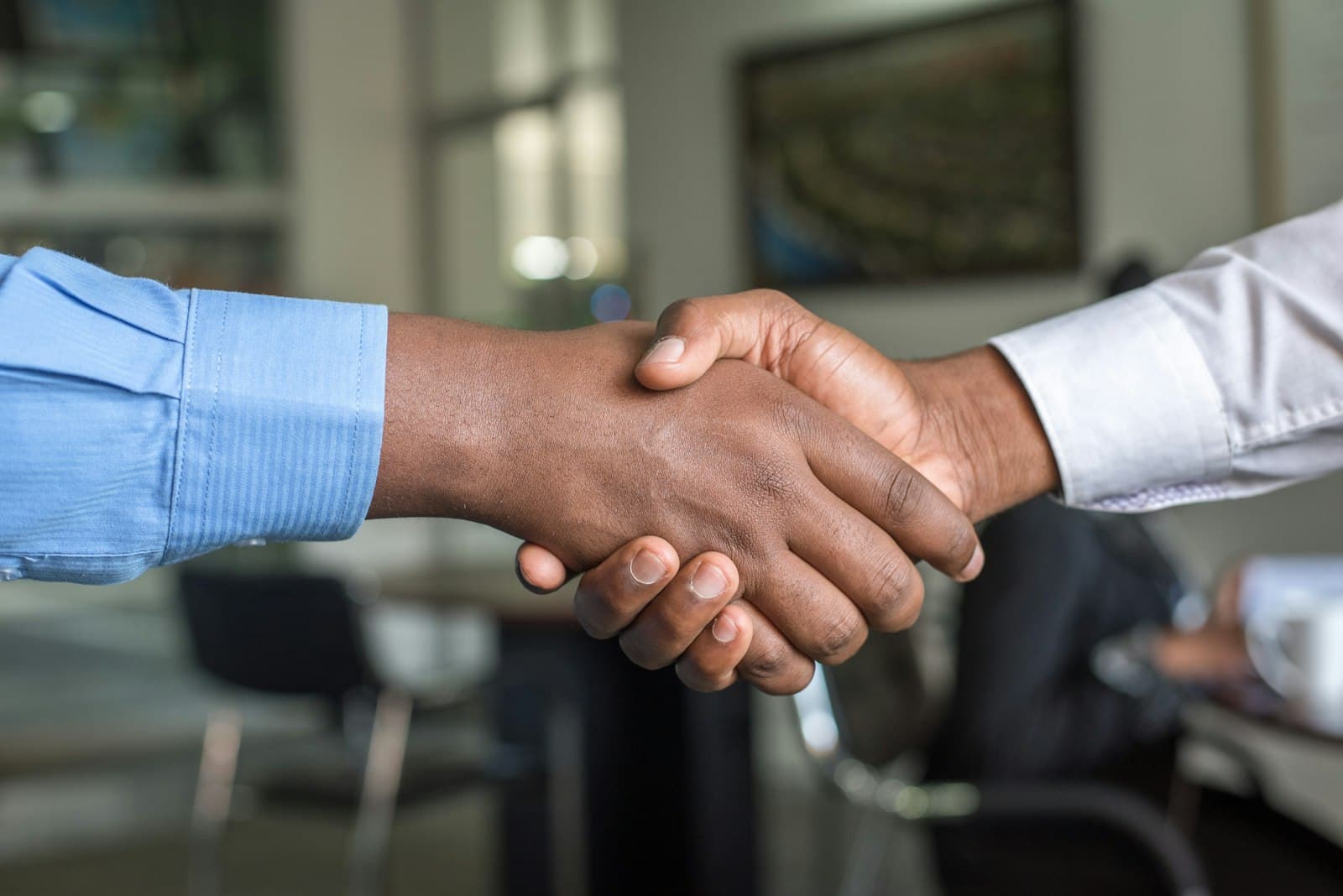 Two professionals shaking hands across a desk